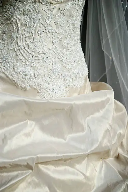 Detail of antique wedding dress in ivory taffeta with traditional beaded bodice