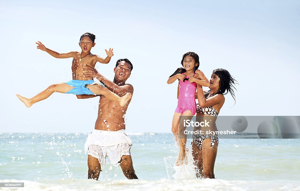 Famiglia asiatica giocando in acqua. - Foto stock royalty-free di Acqua