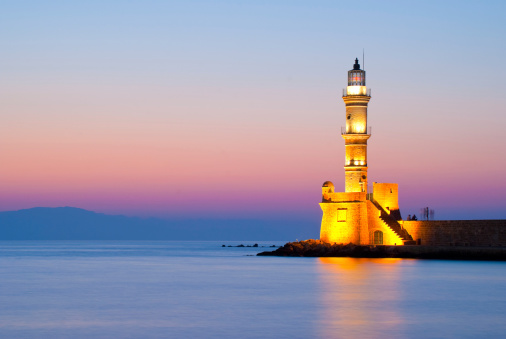 Chania, Crete, Greece - September 27, 2023: A picture of the Lighthouse of Chania, on the right, and the Firka Venetian Fortress, which houses the Maritime Museum of Crete, on the left.