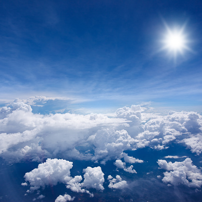 High altitude photo of puffy clouds lit by the sun.