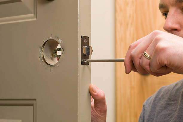 Worker Replacing House Door Latch