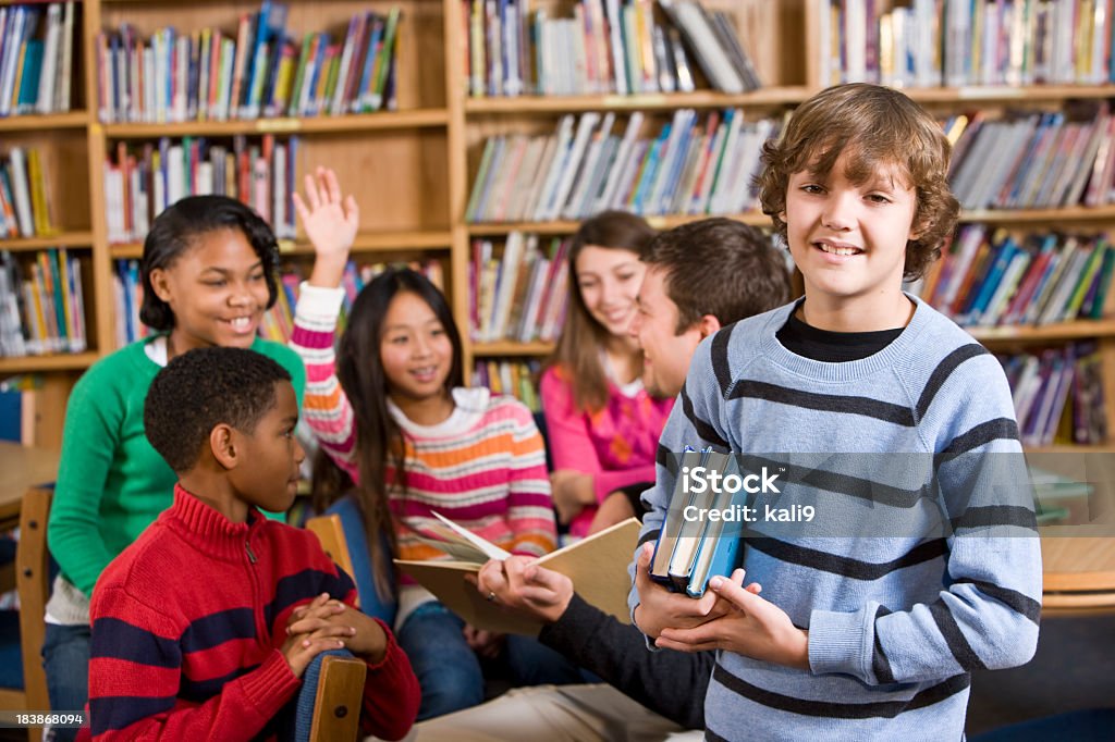 Lächelnden Jungen in der Schule, der Bibliothek, die Bücher zu lesen, Gruppe von - Lizenzfrei 10-11 Jahre Stock-Foto