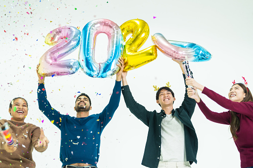 group of people holding fantasy color balloons bubble of the number 2024 for the new Year. men and women standing on a white background. celebration of happy new year Party