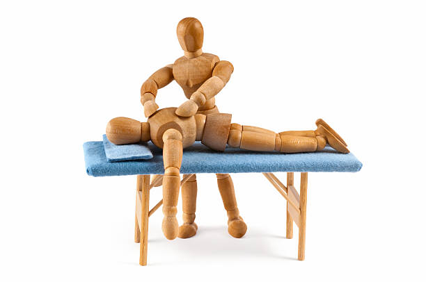 Wooden toy figure of patient on blue - medical background