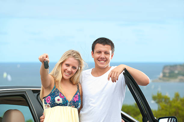 istock Young couple standing beside a car 183870013