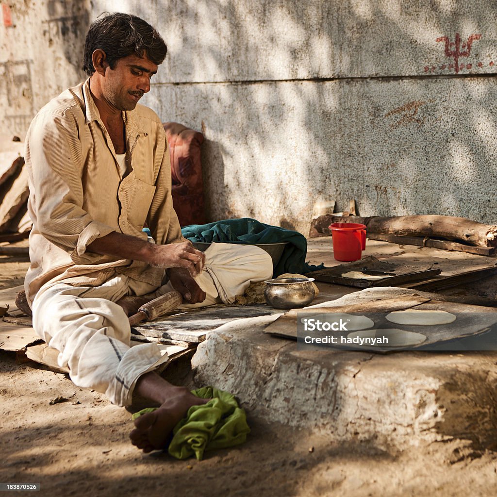 Indiano uomo preparando chapatti pane di Delhi - Foto stock royalty-free di Focaccia azzima