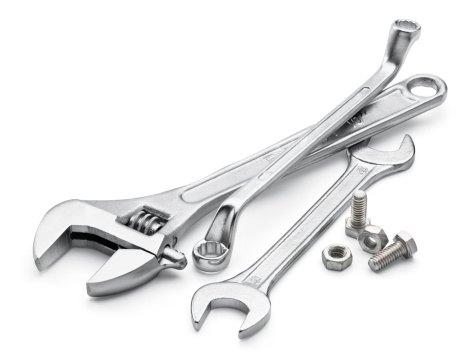 various type of spanners with bolts and nuts over white