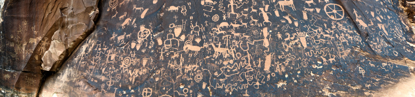 Panorama of hundreds of petroglyphs carved into the desert varnish at Newspaper Rock in Utah near the entrance to Canyonlands National Park.
