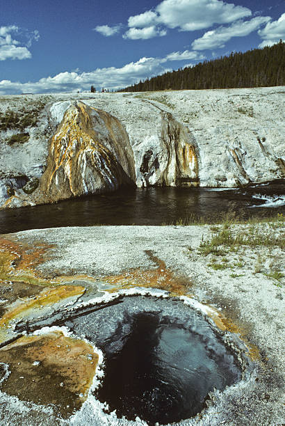 Firehole River and Hot Spring The Firehole River is one of the two major tributaries of the Madison River. Its source is Madison Lake on the Continental Divide. The river and one of many hot springs were photographed from the Old Faithful area in Yellowstone National Park, Wyoming, USA. jeff goulden yellowstone national park stock pictures, royalty-free photos & images