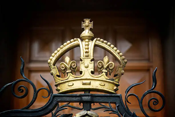 Photo of Decorative Gold Crown on Wrought Iron Gate