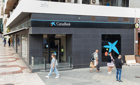Málaga - Spain - 30th October 2023: Exterior of, and entrance to, the branch of CaixaBank on Calle Armengual de la Mota, in central Málaga.  CaixaBank is a Spanish financial services company headquartered in Valencia.