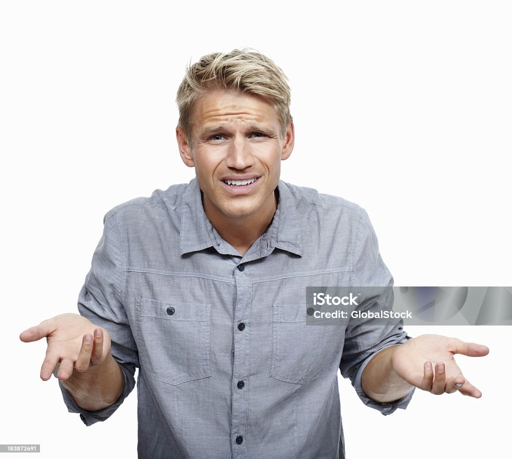 Young man shrugging in surprise Portrait of young man shrugging in surprise on white background 20-29 Years Stock Photo