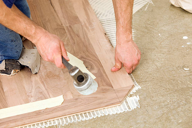 istock Worker Installing Walnut Hardwood Floor over Concrete 183872835