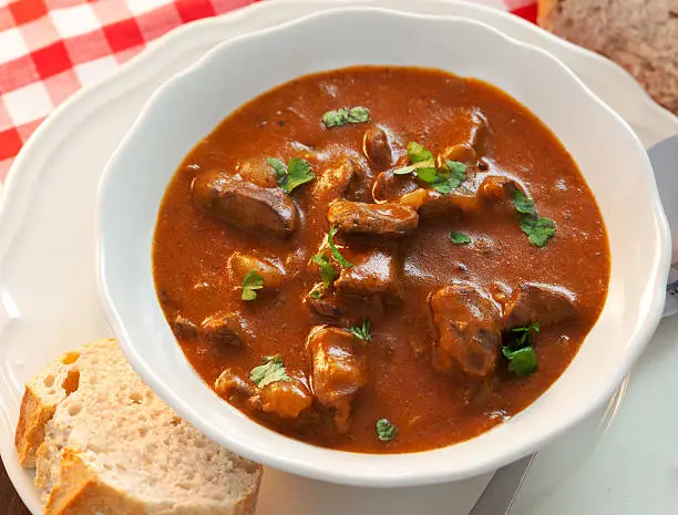 Delicious goulash served with fresh baguette