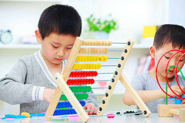 istock two asian kids playing in kindergarden 183874187