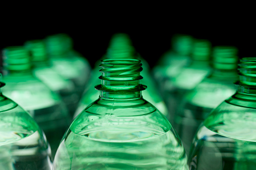 Green glass bottles typical of the culture of the island of Mallorca, displayed in a street market on white and blue fabrics