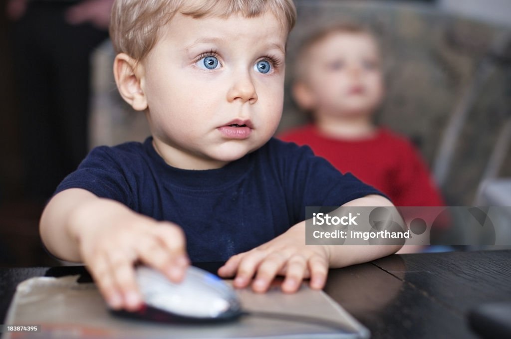 Computer boys Little boy using computer. Focus on the boy'eye. Shallow DOF. Fine noise applied. Computer Mouse Stock Photo