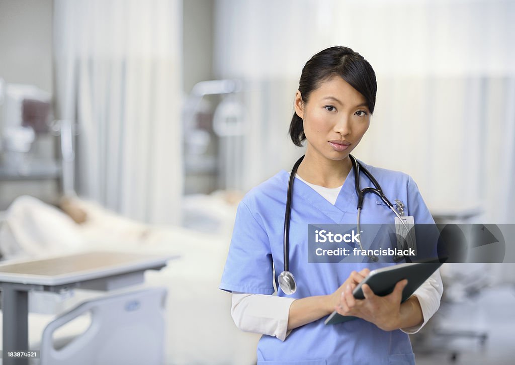 Joven enfermera trabajando en tableta - Foto de stock de Adulto libre de derechos