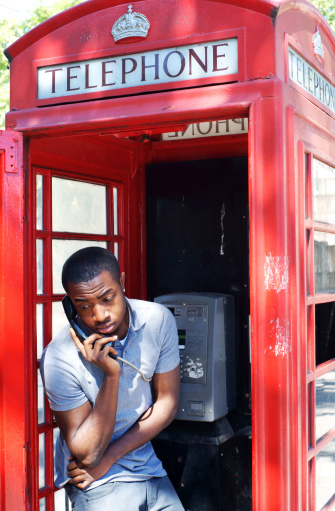 Red telephone booth in London with Big Ben on background.