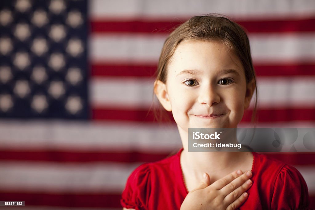 Ragazza felice con Mano sul cuore con bandiera americana - Foto stock royalty-free di Bambino