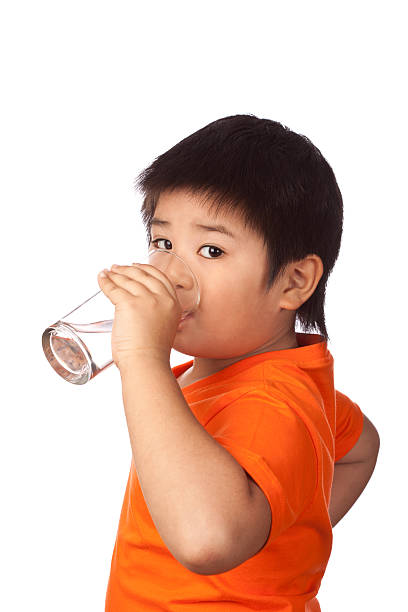 Japanese/Asian boy drinking water from a glass.