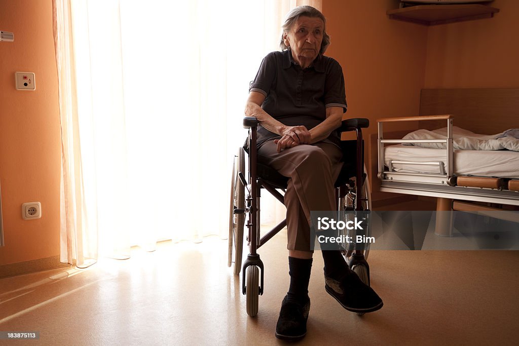 Senior mujer en silla de ruedas en una residencia de ancianos habitación - Foto de stock de Silla de ruedas libre de derechos