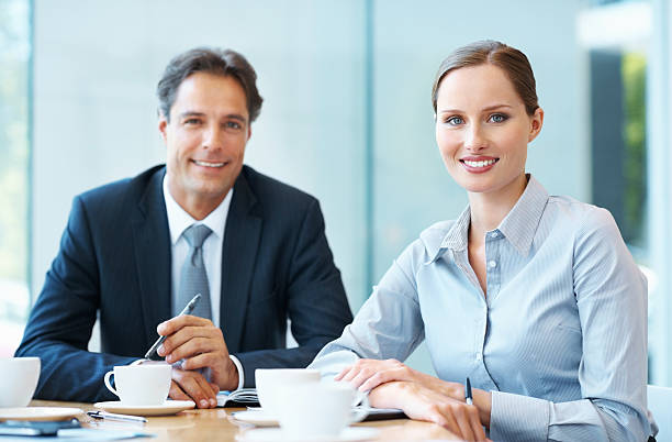 istock Male and female executives smiling 183875597