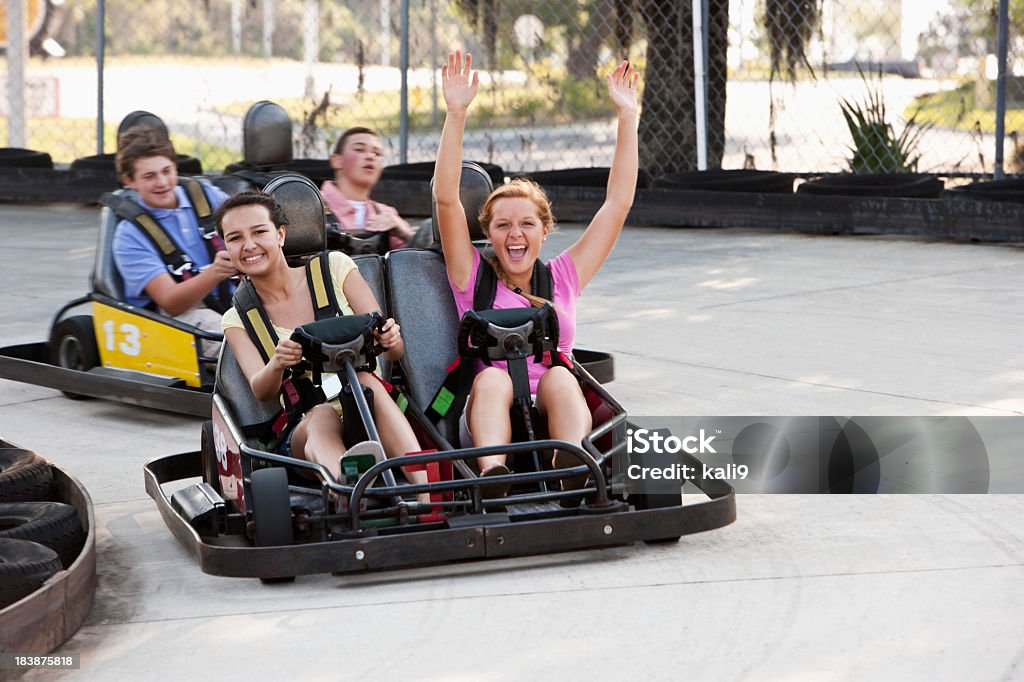 Teenagers riding go-carts Teenage friends, 14 to 16 years, riding go-carts.  Focus on girls Go-cart Stock Photo