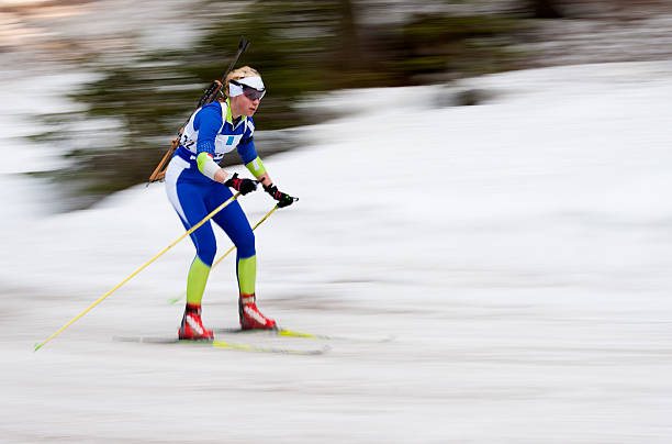 "Portrait of  female biathlon competitor at the downhill, panning"