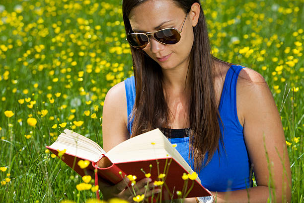 istock Cute young girl reading book on a park 183876707