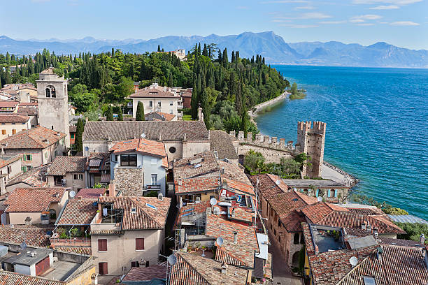 Sirmione stands on a peninsula that stretches out for about 4 km in the Lake Garda, surrounded by clear waters. It is the most visited and loved locality around the lake, appreciated for its climate and for the medieval borough with all the history enclosed by its walls. An example is the imposing thirteenth-century castle, the Rocca Scaligera, from where this picture has been taken. Lake Garda, Italy. Canon EOS 5D Mark II.