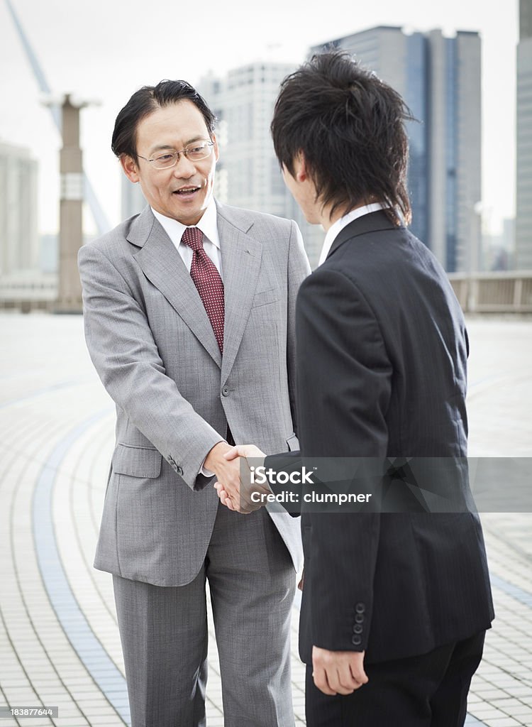 Asian empresários trocam apertos de mãos - Foto de stock de 20 Anos royalty-free