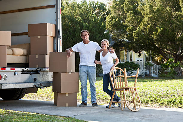 istock Young couple with moving van in driveway 183878486