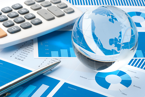 Financial papers with globe paperweight