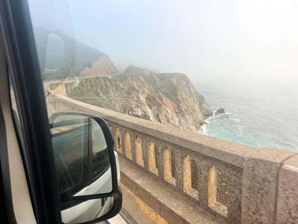 mystic drive: autofahrt durch den nebligen big sur und die bixby-brücke - fog bridge california balance stock-fotos und bilder