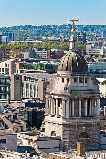 High angle view over the rooftops and spires of London as the golden Lady Justice, scales and sword in hand, looks out over the city from the dome above the Old Bailey, Central Criminal Court. ProPhoto RGB profile for maximum color fidelity and gamut.