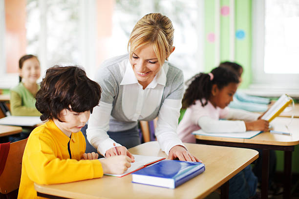 istock Young teacher is helping a pupil with his task. 183879710