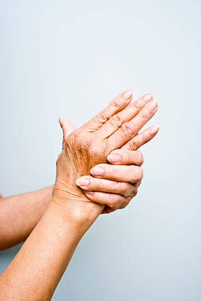 mujer de edad avanzada con la artritis en sus manos - pain joint human hand arthritis fotografías e imágenes de stock