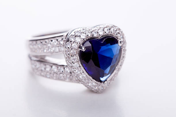 Lady's ring is decorated with fan-shaped design. The design is enriched by a set of green colored stones, that inserted with 3 white ones. The ring is placed on soft white wool.