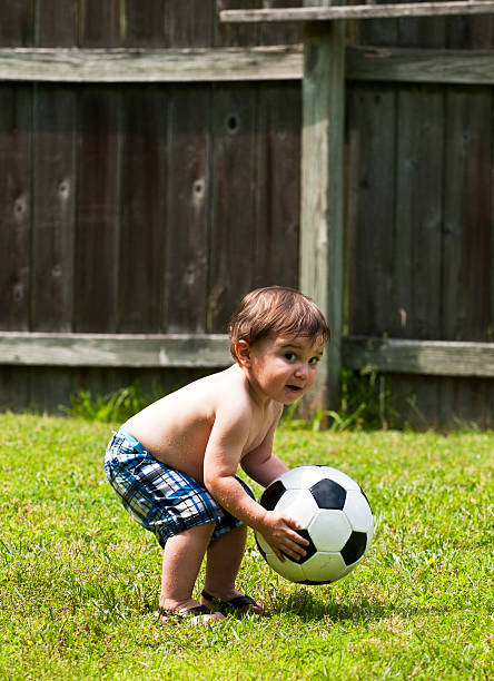 Boy and Soccer ball young boy playing with soccer ball.Other images in this series: baby squatting stock pictures, royalty-free photos & images