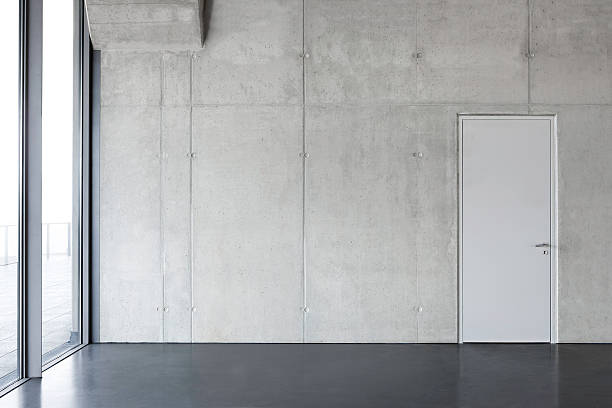 gray pared de cemento con una puerta. - concrete wall fotografías e imágenes de stock