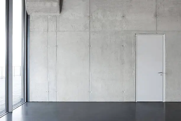 Photo of gray concrete wall with a door.