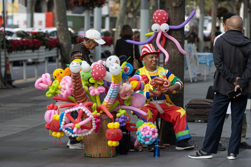 Shanghai, China - Oct 23, 2023: A balloon artist on the streets in the Jing'an District of Shanghai during the Chongyang Festival (also known as the Double Ninth Festival).