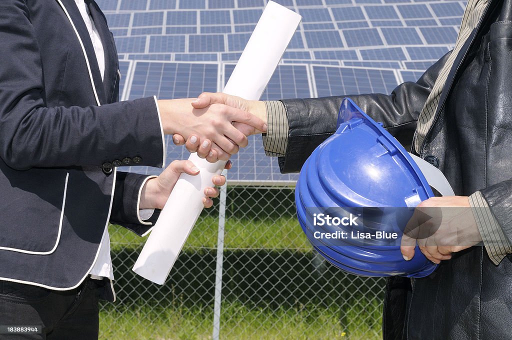 Feminino engenheiros apertando as mãos em uma usina de energia Solar - Foto de stock de Dar as Mãos royalty-free