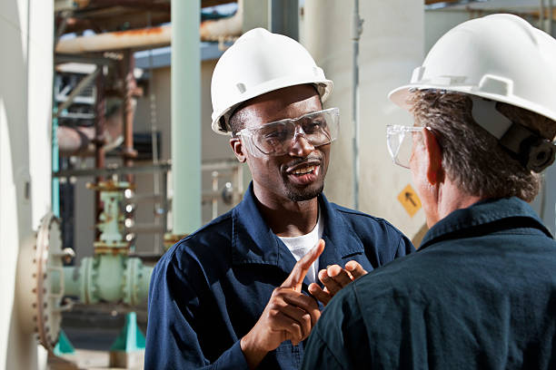 multirazziale lavoratori in pianta industriale di discussione - manufacturing occupation african descent refinery manual worker foto e immagini stock