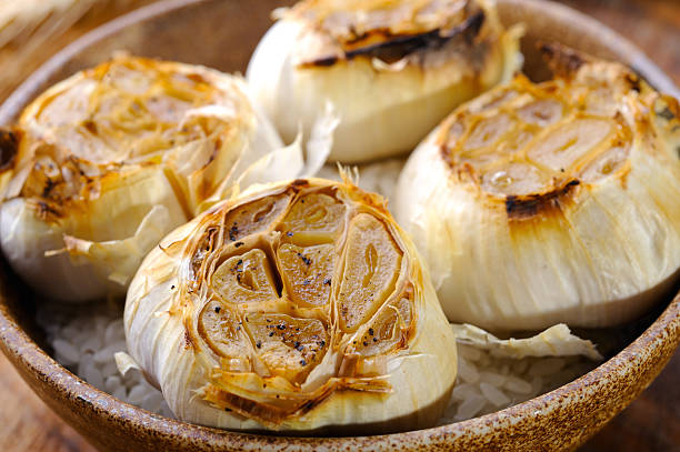 жареный чеснока - roast garlic стоковые фото и изображения
