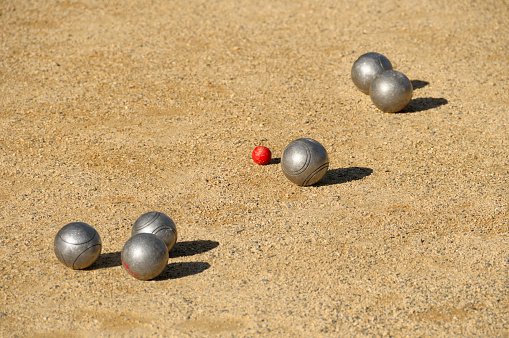 Six boules and a red cochonnet on the court. France