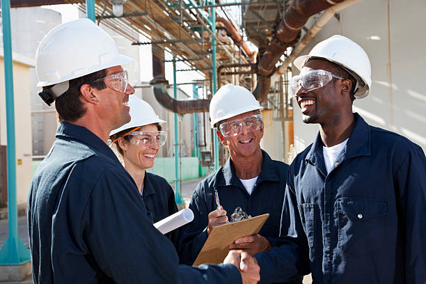 gruppo di lavoratori riunione presso uno stabilimento di produzione - manufacturing occupation african descent refinery manual worker foto e immagini stock