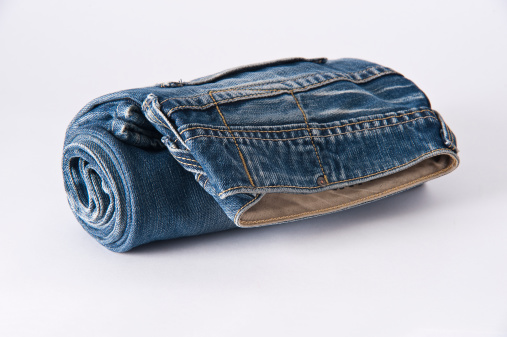 Rolled up blue jeans on white background