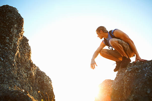istock Young man sitting on the edge of a rock 183886433